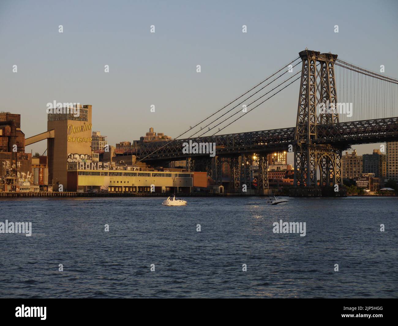 Domino Sugar Refinery und Williamsburg Bridge, Brooklyn, vom East River aus gesehen, New York City, Juni 2012 Stockfoto