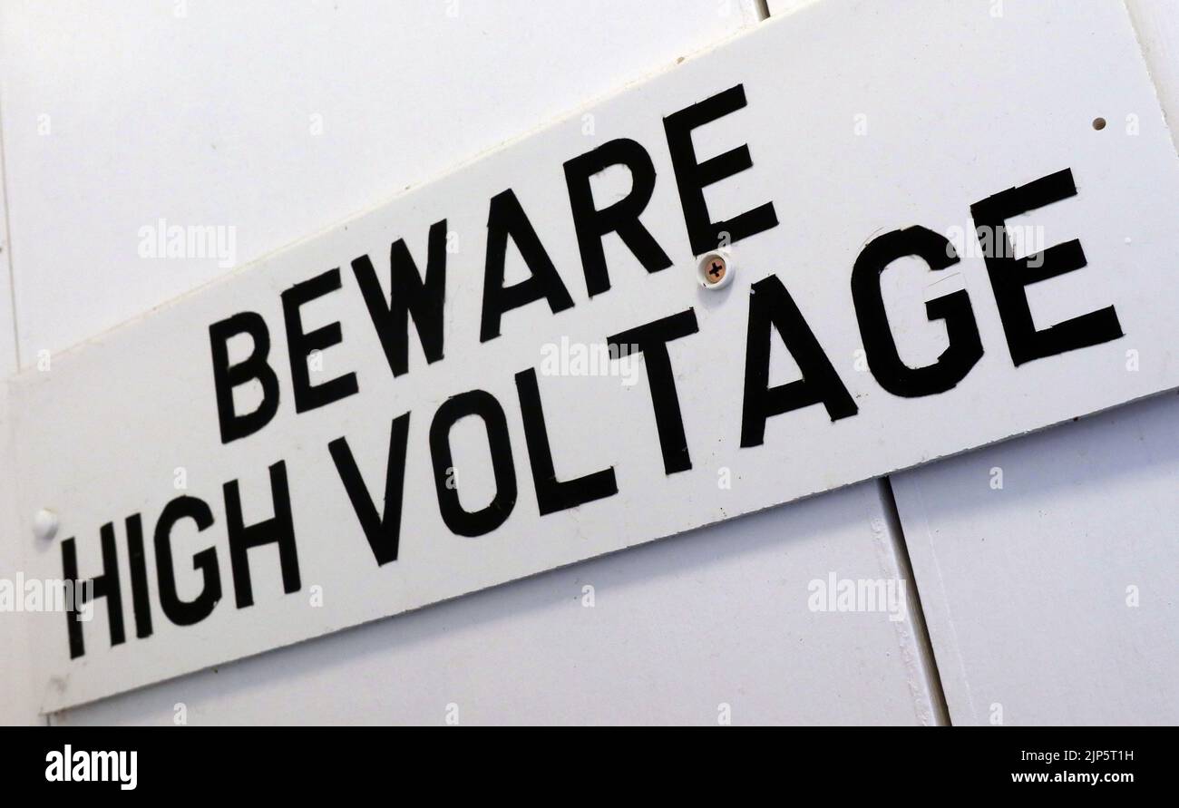 Achtung: Hochspannung - Gefahr für Gesundheit und Sicherheit an elektrischen Anlagen, auf Englisch verfasst Stockfoto