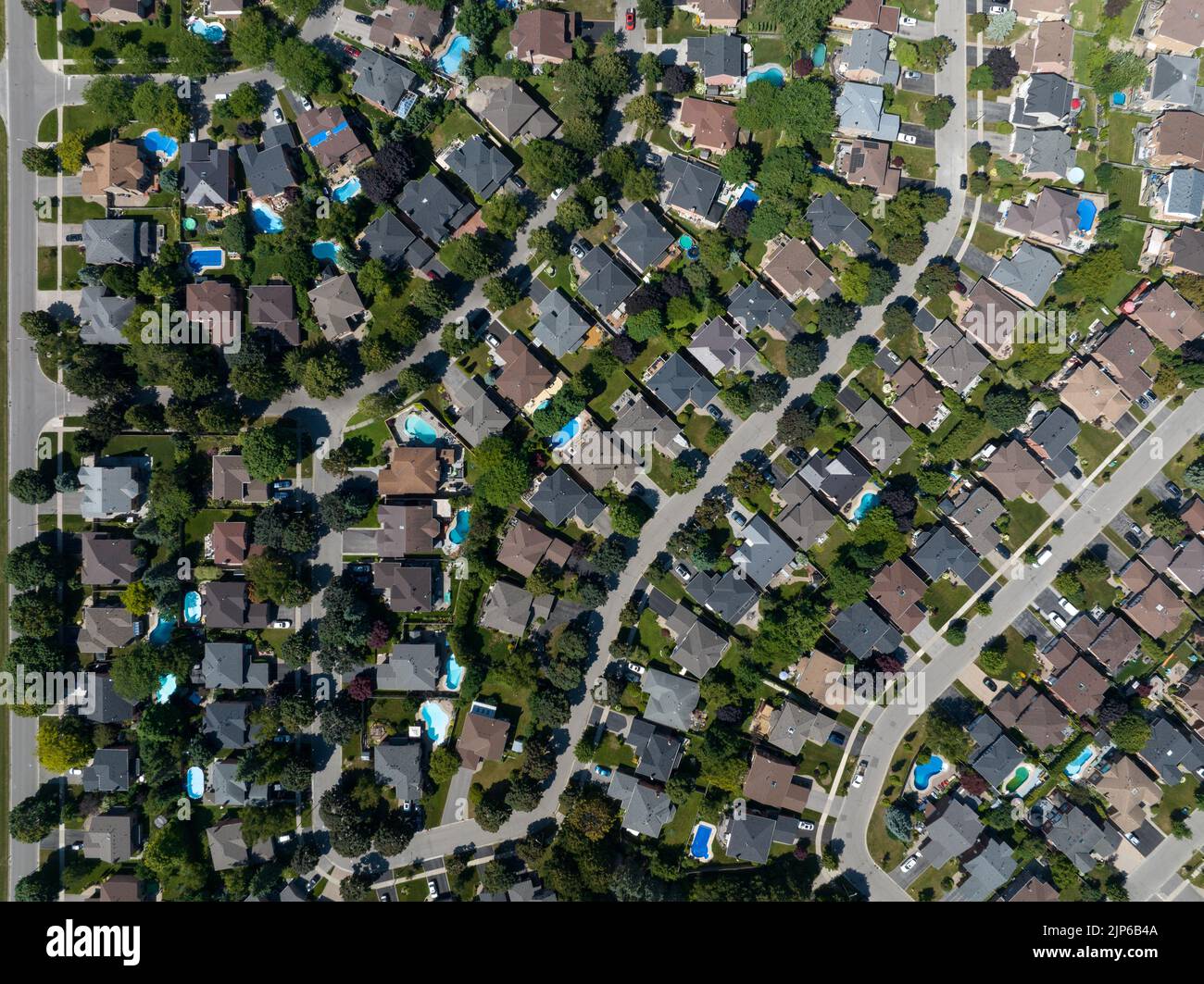 Eine direkte Luftaufnahme über einem riesigen Wohnviertel, gesehen an einem sonnigen Tag im Sommer. Stockfoto