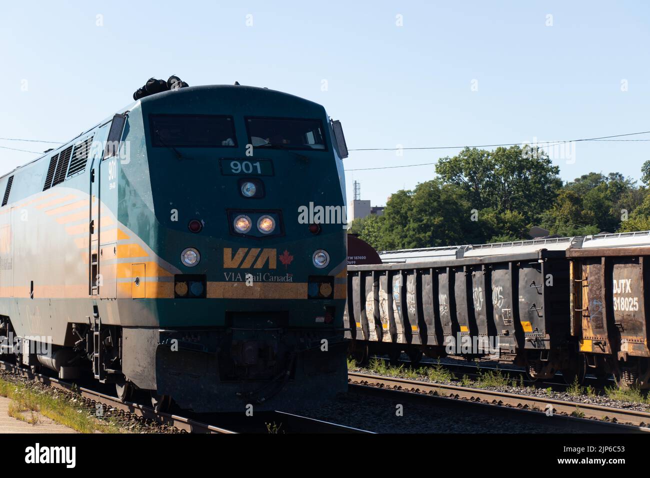 Nahaufnahme eines PERSONENZUGES DER VIA Rail Canada, der tagsüber durch einen Bahnhof fährt. Stockfoto