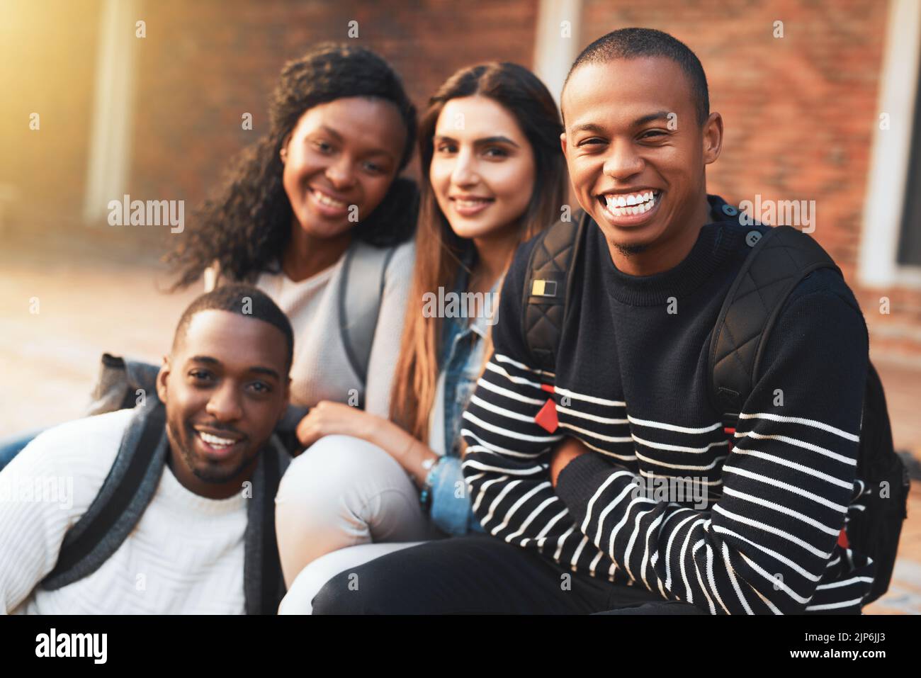 Was ist die College-Erfahrung ohne gute Freunde. Porträt einer Gruppe von Studenten, die sich während einer Pause auf dem Campus entspannen. Stockfoto