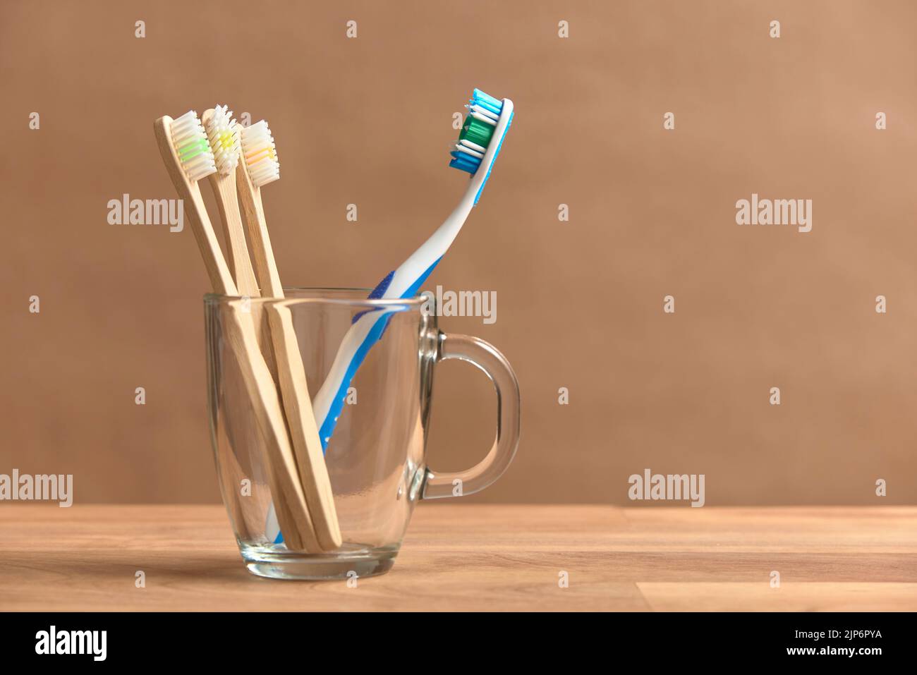 Zahnbürsten, eine Plastikbürsten und ein Satz von drei ökologischen aus Bambus. Konzepte: Nachhaltiger Lebensstil, Auswahl an biologisch abbaubaren kompostierbaren und env Stockfoto