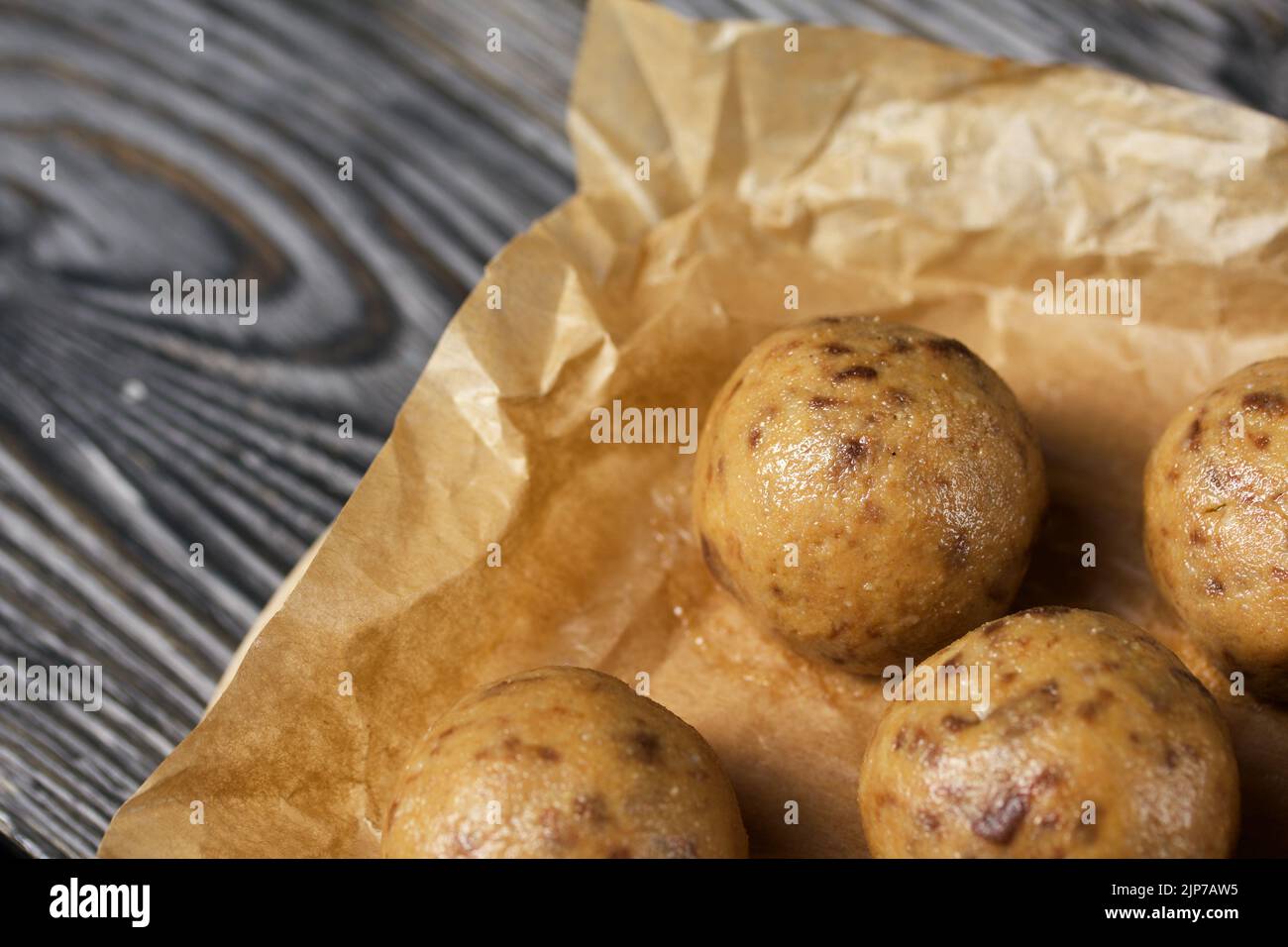 Nützliche hausgemachte Süßigkeiten. Kokosmehl mit dunkler Schokolade. In Form von Bällen. Auf Kiefernbrettern. Stockfoto