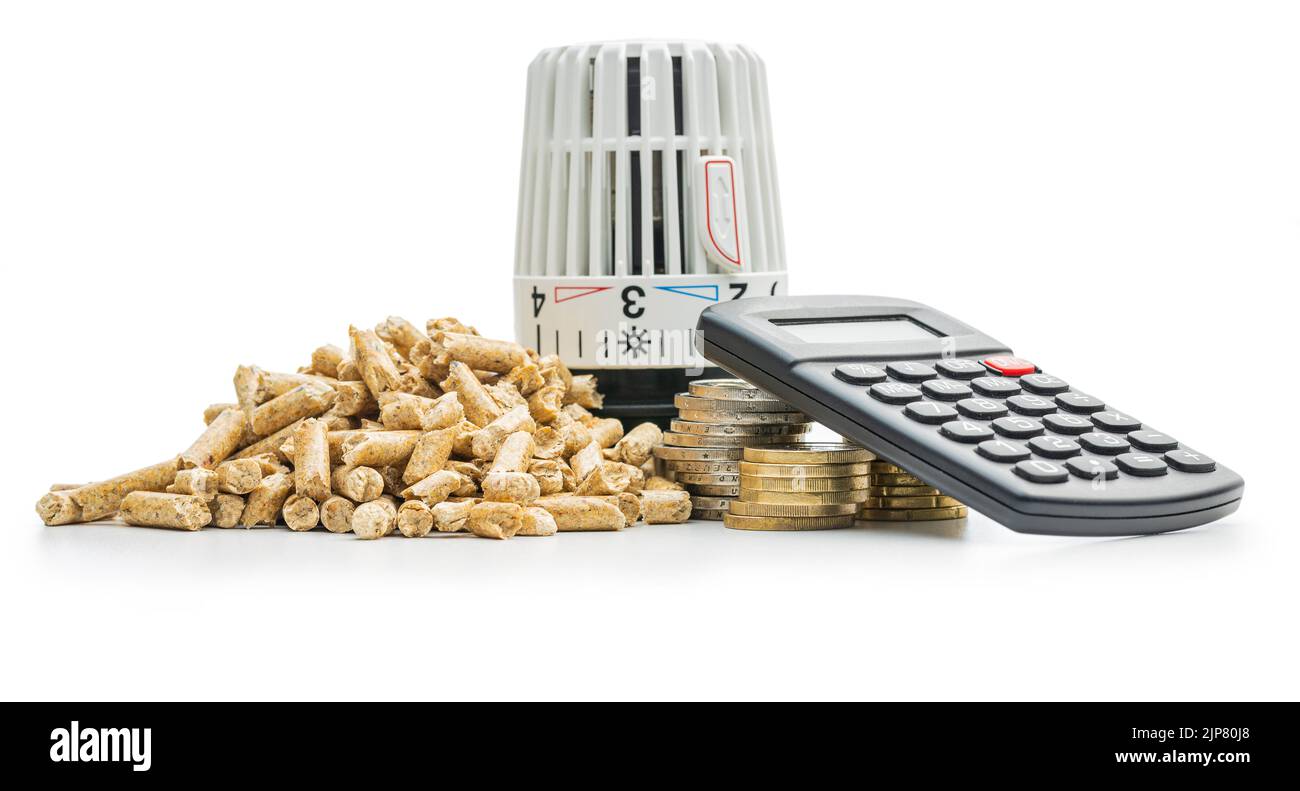 Holzpellets, Taschenrechner, Münzen Geld und thermostatischer Ventilkopf isoliert auf weißem Hintergrund. Biomasse - Erneuerbare Wärmequelle. Stockfoto