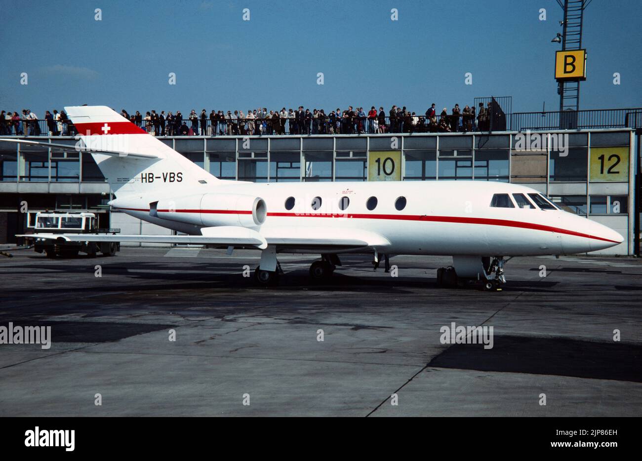 A Dassault Falcon 20, 20C, Business, Executive, Corporate, Privatjet, in der Schweiz als HB-VBS registriert. Viele Menschen stehen und beobachten Flugzeuge am Flughafen. Stockfoto