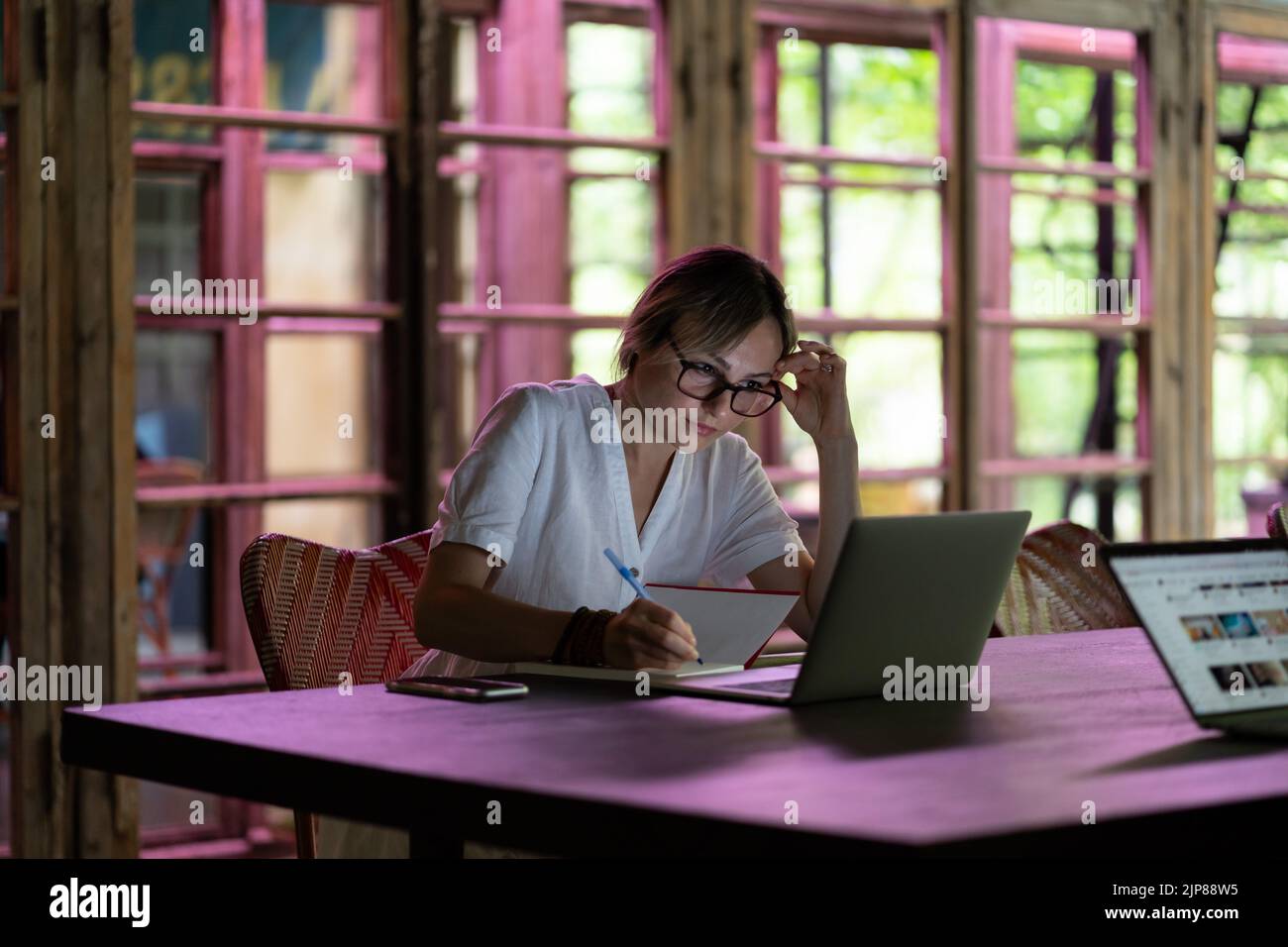 Konzentrierte kaukasische Studentin, die sich im Coworking Space einen Webinar-Videokurs auf dem Laptop ansieht Stockfoto