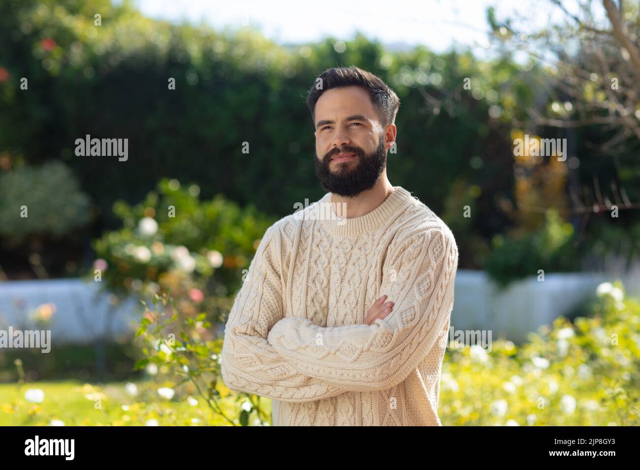 Glücklicher kaukasischer Mann mit lächelndem Bart, der im Garten stand Stockfoto