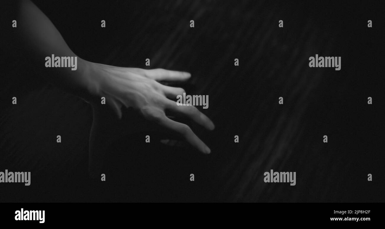 Bild einer Hand, die im dunklen Raum geht Stockfoto