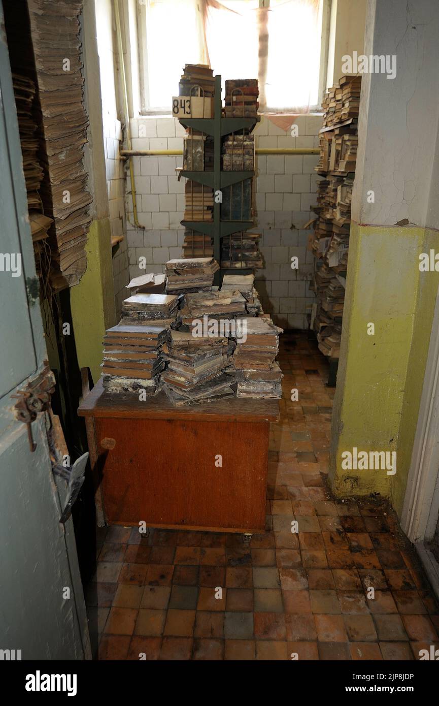 Stapel sehr alter Bücher unter schlechten Bedingungen, ein Archivraum der Uzhgorod National University. Uschgorod, Ukraine. Stockfoto