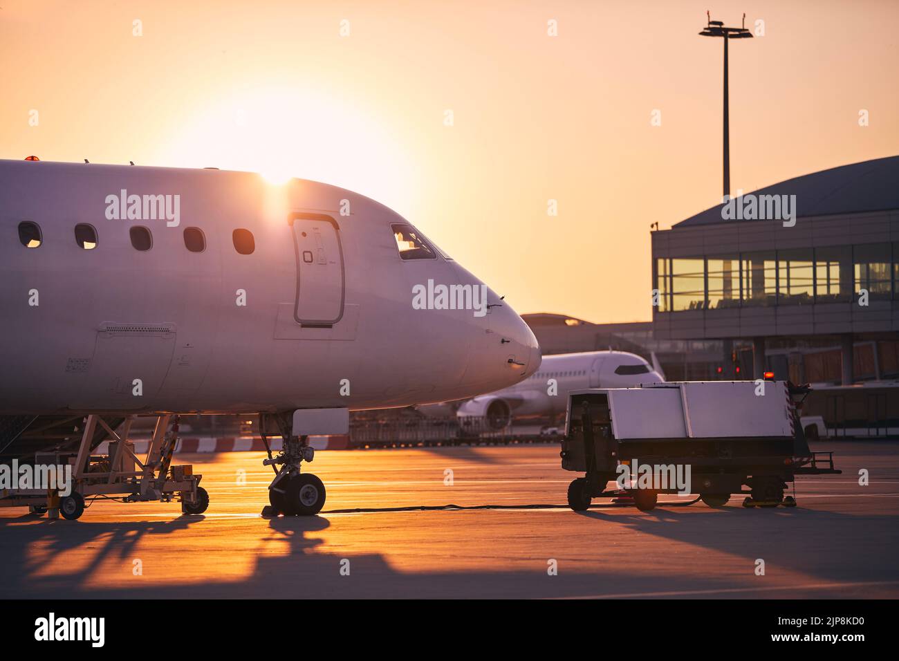 Vorbereitung der Flugzeuge vor dem Flug. Flughafen bei goldenem Sonnenaufgang. Stockfoto