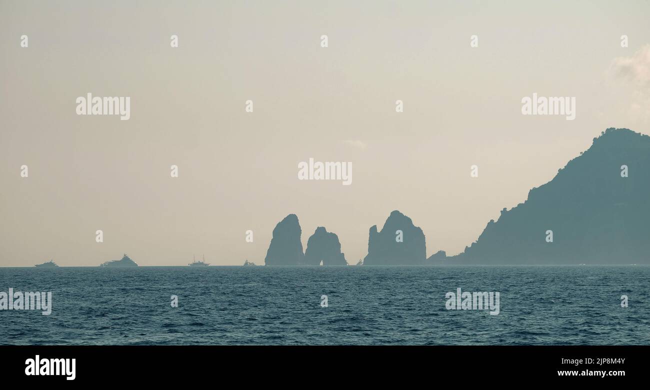 Capri faraglioni Wellenerosion Felsformationen Meereslandschaft der Insel Capri Italien in der Bucht von Neapel im Meeresnebel mit Vergnügungsbooten gesehen. Stockfoto