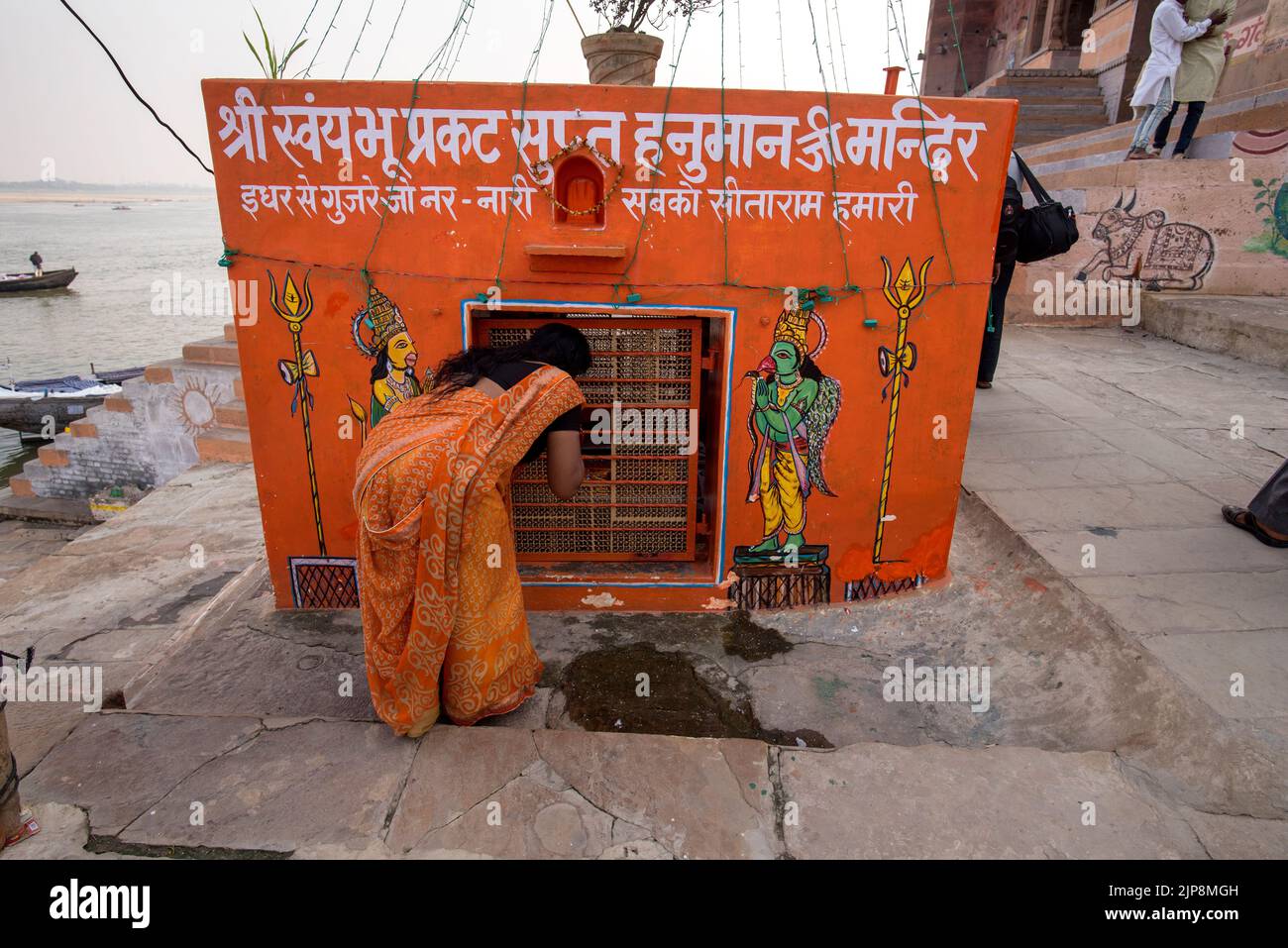 Frau, die im Hanuman-Tempel auf Ganga Ghat, Varanasi, Banaras, Benaras, Kashi, Uttar Pradesh, Indien Stockfoto