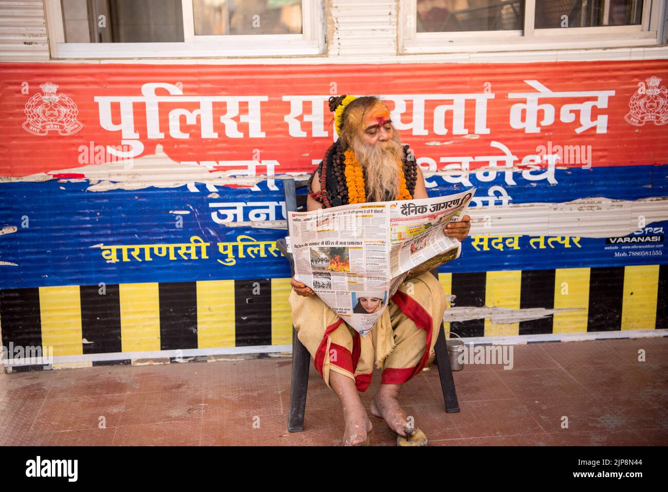 Sadhu liest die Hindi-Zeitung, Varanasi, Banaras, Benaras, Kashi, Uttar Pradesh, Indien Stockfoto