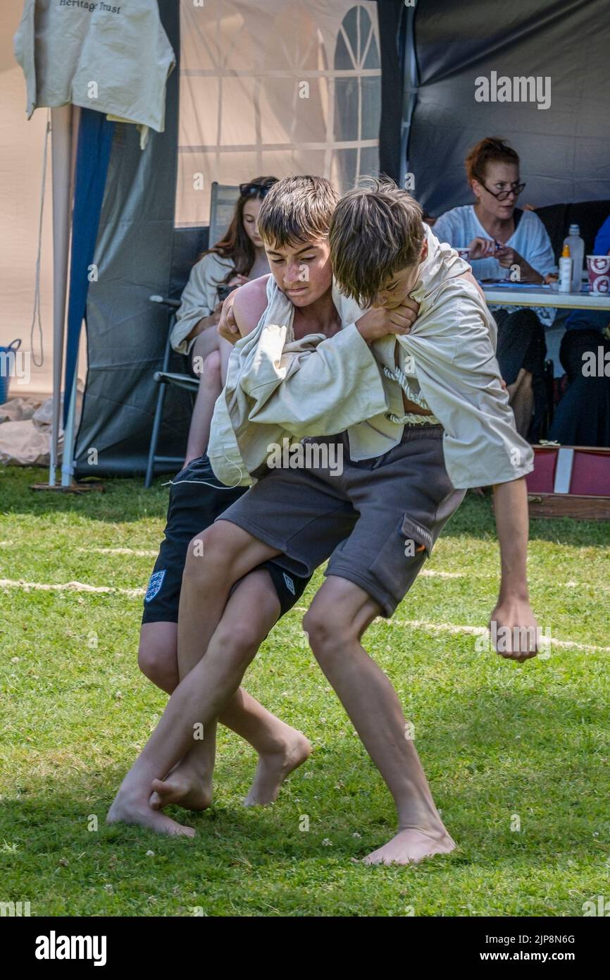 Zwei junge Brüder im Teenageralter treten beim Grand Cornish Wrestling Tournament auf dem malerischen Dorfgrün von St. Mawgan in Pydar in Cornwall in an Stockfoto