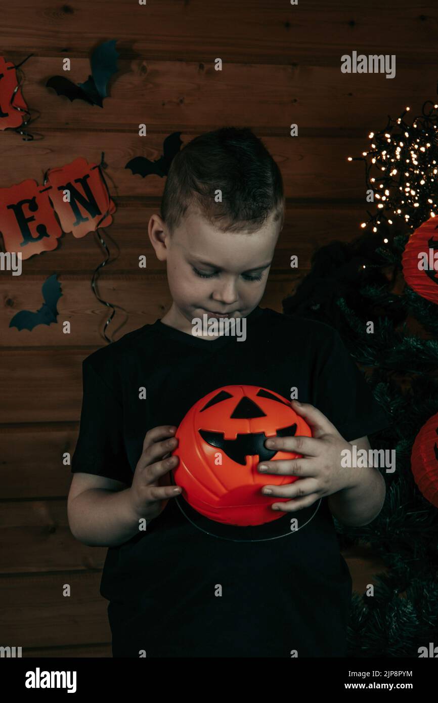 Halloween Kinder. Niedlicher kleiner Junge, Kind mit orangefarbenem Jack O Lantern Candy Eimer. Frohe Halloween. Halloween Hintergrund. Stockfoto