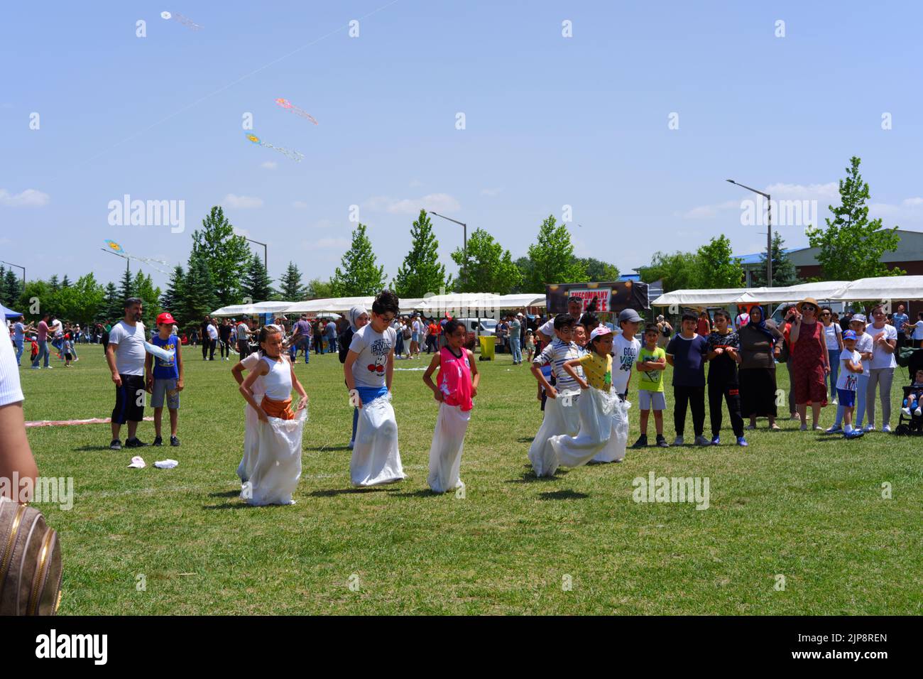 Menschen und Kinder haben Spaß beim Gunnysack-Rennen im Sommer im Freien Stockfoto