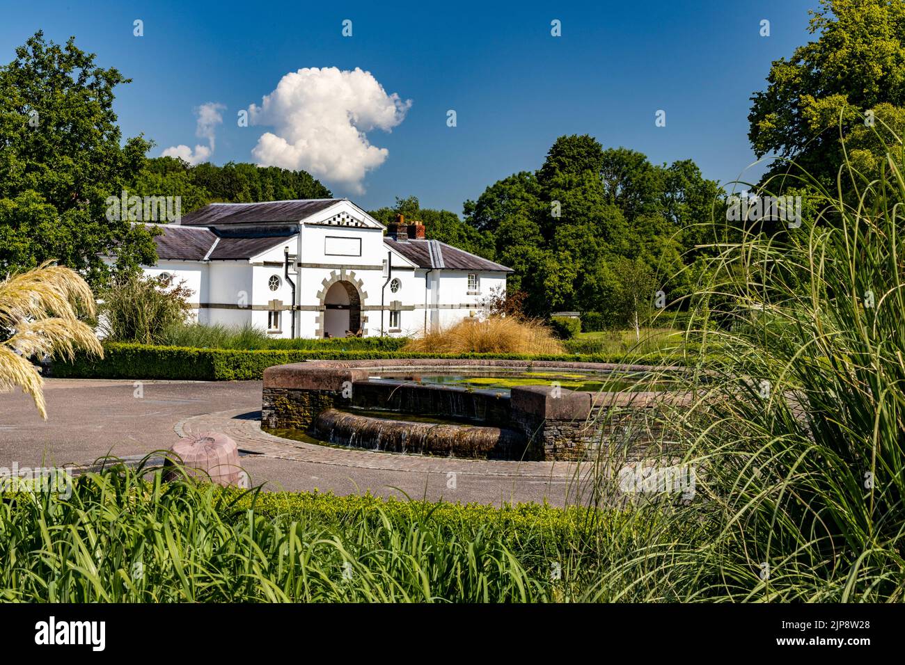 Der alte Stallblock und das Wasserspiel im National Botanic Garden of Wales, Llanarthne, Carmarthenshire, Wales, Großbritannien Stockfoto