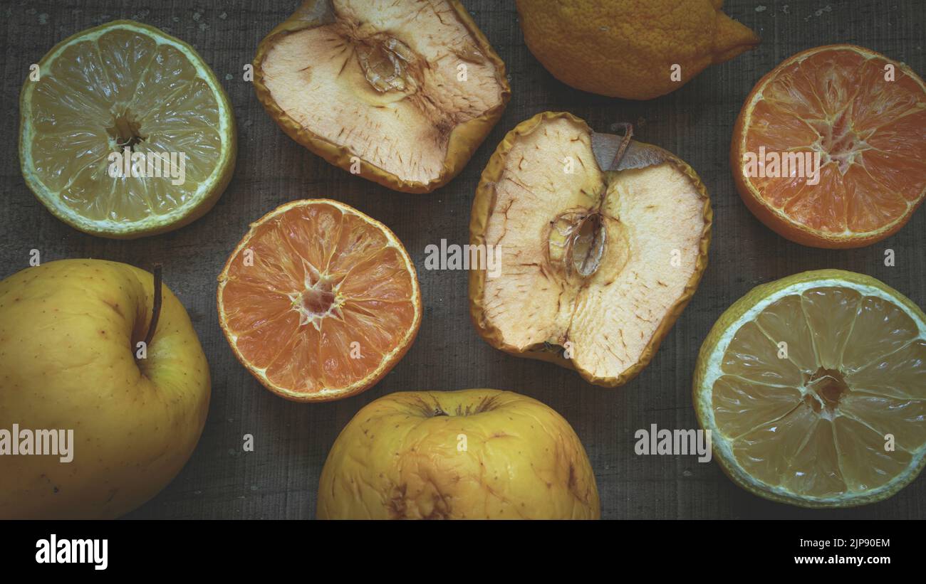 Stillleben von Früchten, Zitrone, Orange und Apfel, im Prozess der Alterung oder Rost auf einem dunklen Holztisch Stockfoto