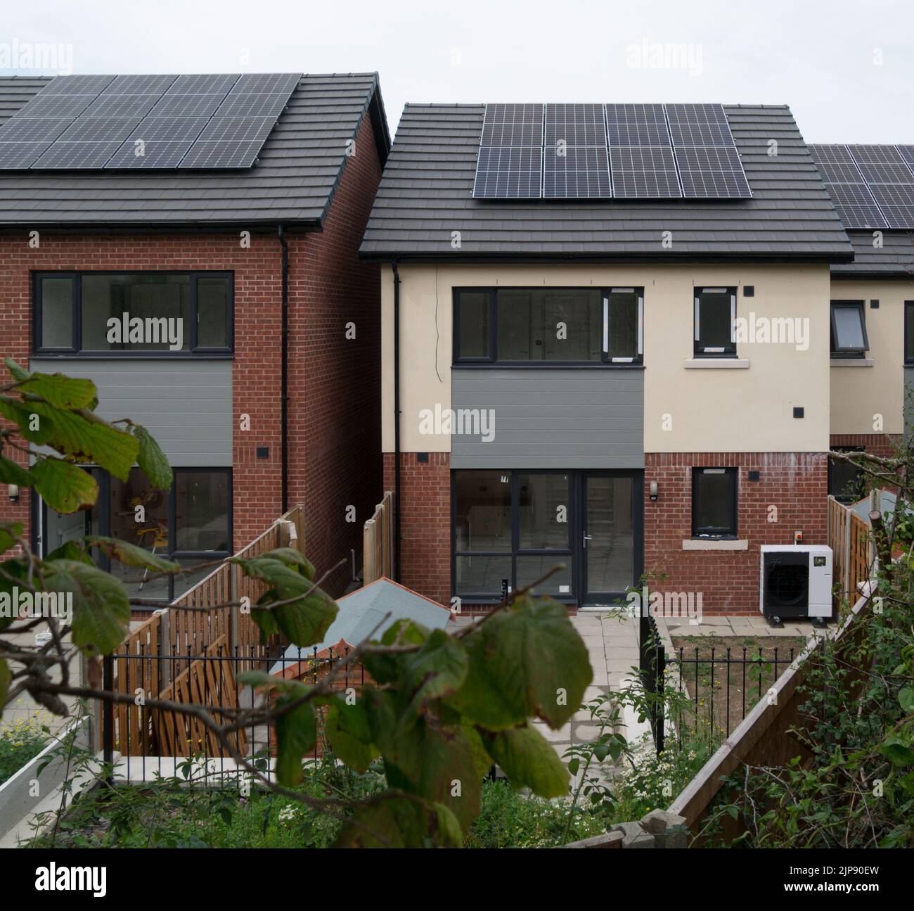 Neubau Häuser mit Sonnenkollektoren auf dem Dach und Luftquelle Wärmepumpe Einheit für billige Strom installiert Senkung der Energiekosten Nord-Wales Stockfoto