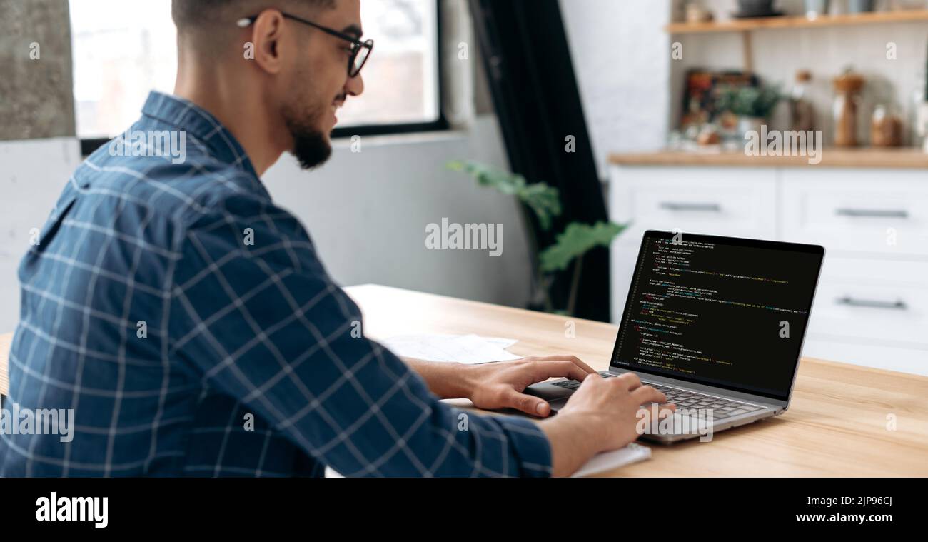 Panorama-Seitenansicht Foto eines Programmierers mit Laptop. Clever erfolgreicher Kerl, ein IT-Spezialist, Software-Entwickler, verwendet Laptop, männlichen Programmierer schreibt Codes für eine Anwendung. IT-Technologie Stockfoto