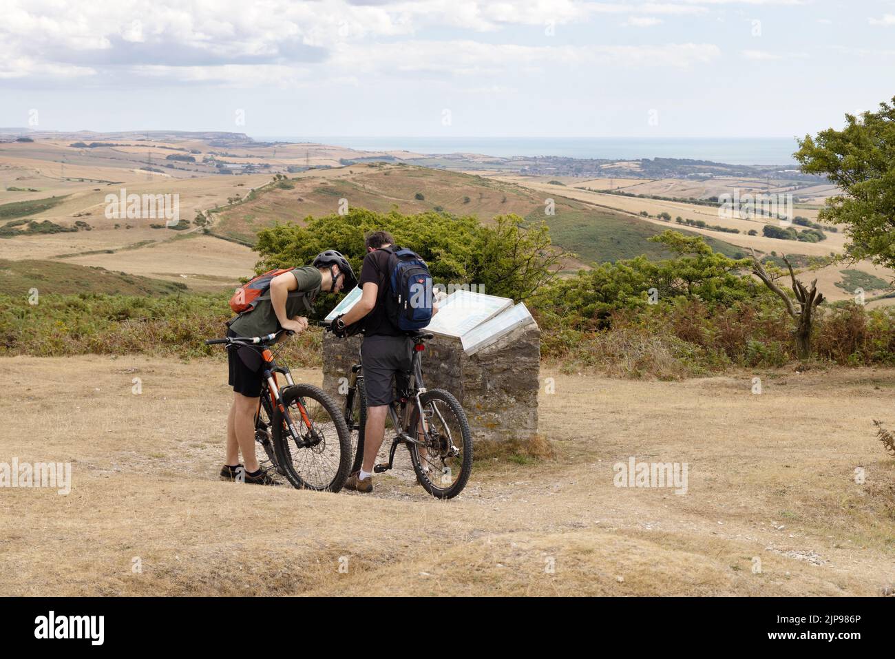 Radfahren in Großbritannien; zwei Männer im Alter von 30s Jahren mit ihren Fahrrädern auf dem Black Down Summit in Dorset Countryside, Dorset UK. Beispiel für einen gesunden Lebensstil Stockfoto