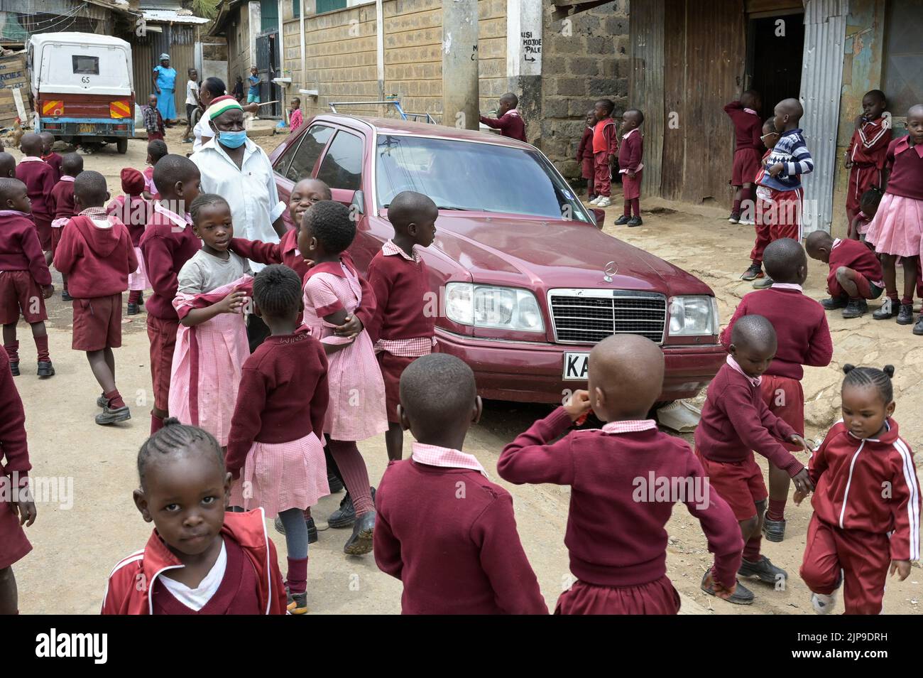 KENIA, Nairobi, Mathare Slum, Kontrastschulkinder und gebrauchte Mercedes Benz Autos aus Europa / KENIA, Nairobi, Stadtteil Mathare, Slum, Kontrast Schulkinder und gebrauchter Mercedes Benz aus Europa Stockfoto