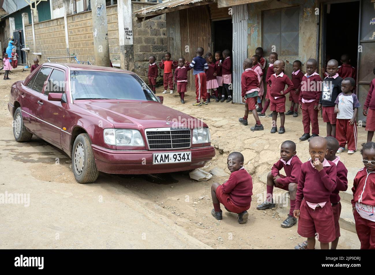 KENIA, Nairobi, Mathare Slum, Kontrastschulkinder und gebrauchte Mercedes Benz Autos aus Europa / KENIA, Nairobi, Stadtteil Mathare, Slum, Kontrast Schulkinder und gebrauchter Mercedes Benz aus Europa Stockfoto