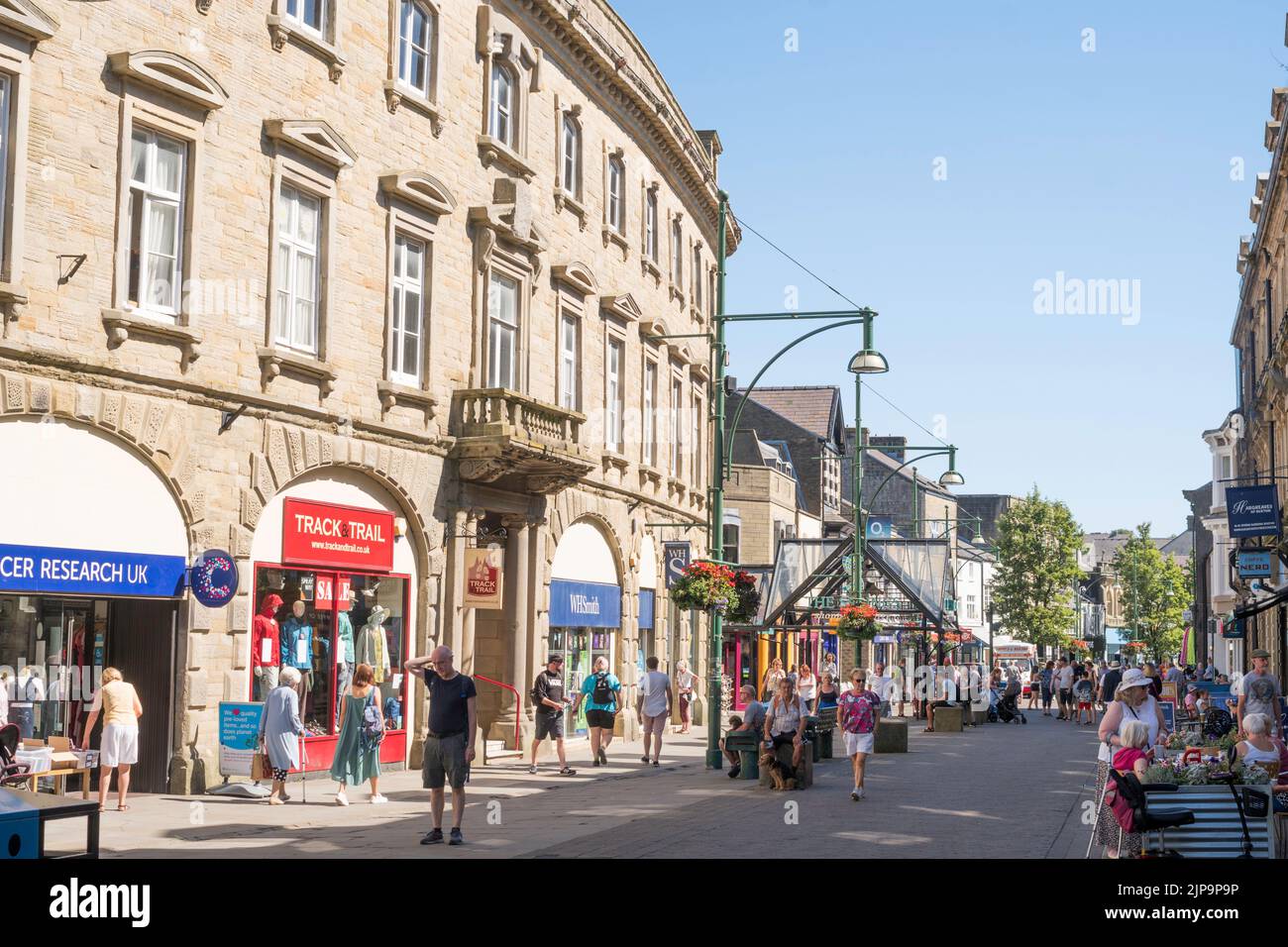 Menschen, die durch das Stadtzentrum von Buxton, Derbyshire, England, Großbritannien, wandern Stockfoto