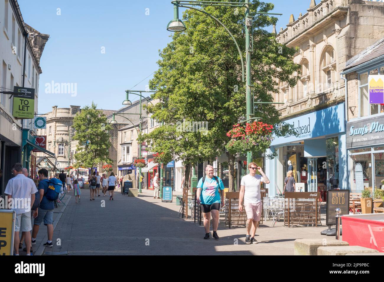 Menschen, die durch das Stadtzentrum von Buxton, Derbyshire, England, Großbritannien, wandern Stockfoto