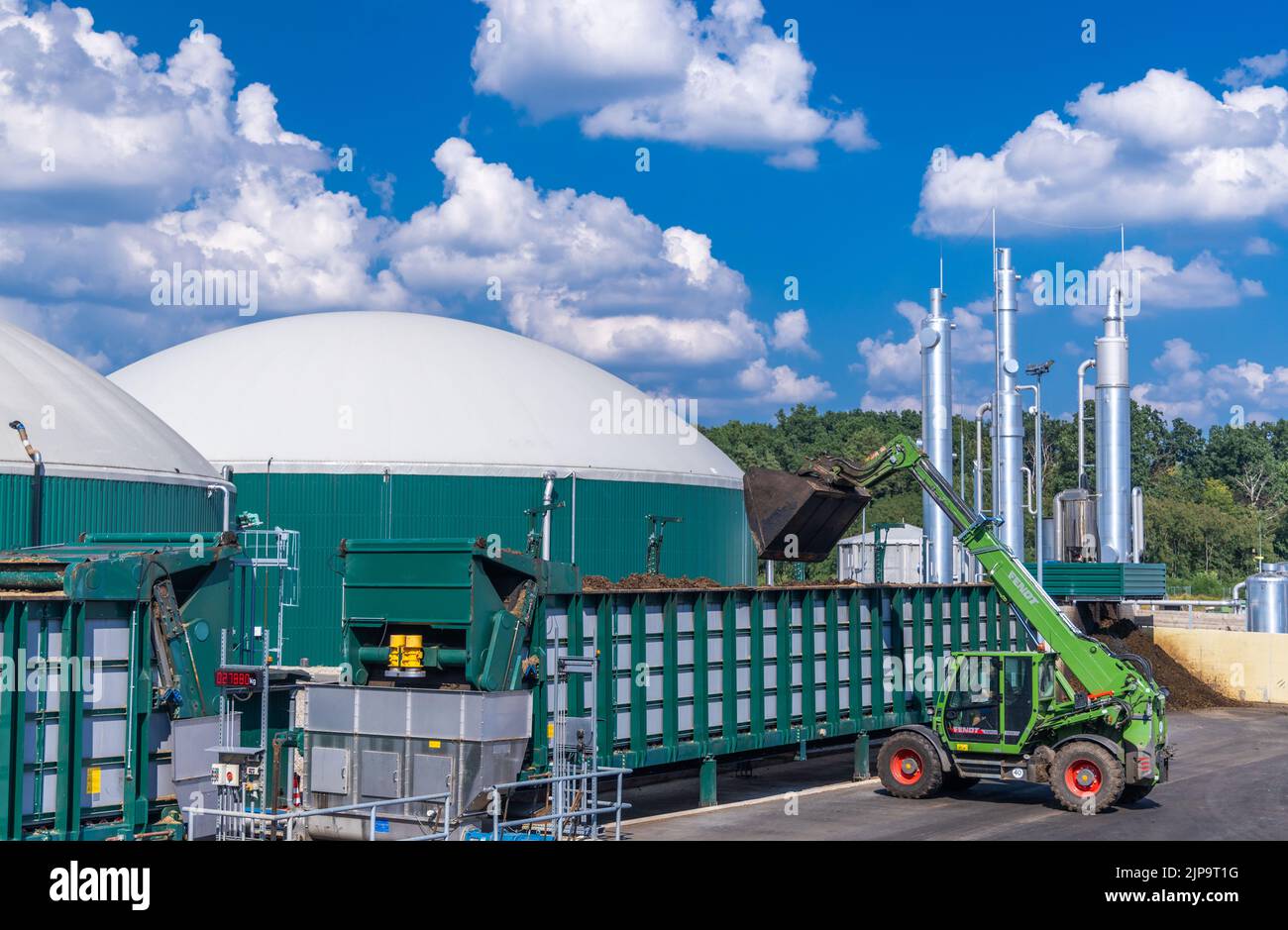 Torgelow, Deutschland. 16. August 2022. Ein Radlader kippt Biomasse in die Biogasanlage in Torgelow, die über insgesamt sechs große Tanks verfügt. Die Anlage wird 15.000 Einwohner der Stadt Torgelow versorgen. Die Anlage der Firma Mele Biogas, die bisher aus sechs Speichertanks bestand, wird bis Herbst 2023 auf die Verdoppelung ihrer Kapazität erweitert. Hier soll nach Angaben des Landesverbands für Erneuerbare Energien Mecklenburg-Vorpommern ein Energievolumen von mehr als 100 Millionen Kilowattstunden pro Jahr produziert und auch in das Erdgasnetz eingespeist werden. Quelle: Jens Büttner/dpa/Alamy Live News Stockfoto