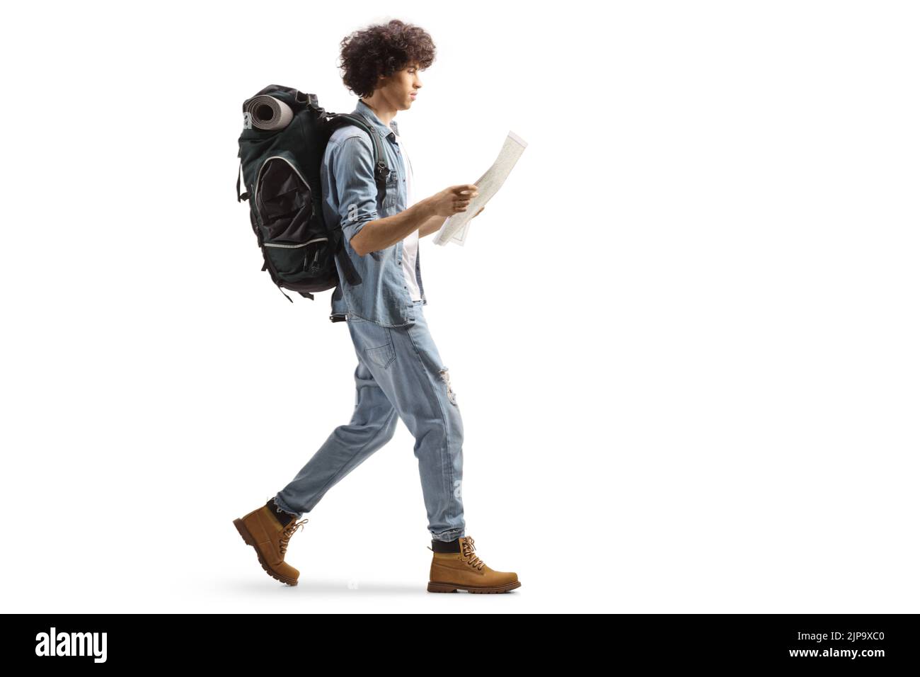 In voller Länge Profil eines männlichen Reisenden mit einem Rucksack zu Fuß und Lesen einer Karte isoliert auf weißem Hintergrund Stockfoto