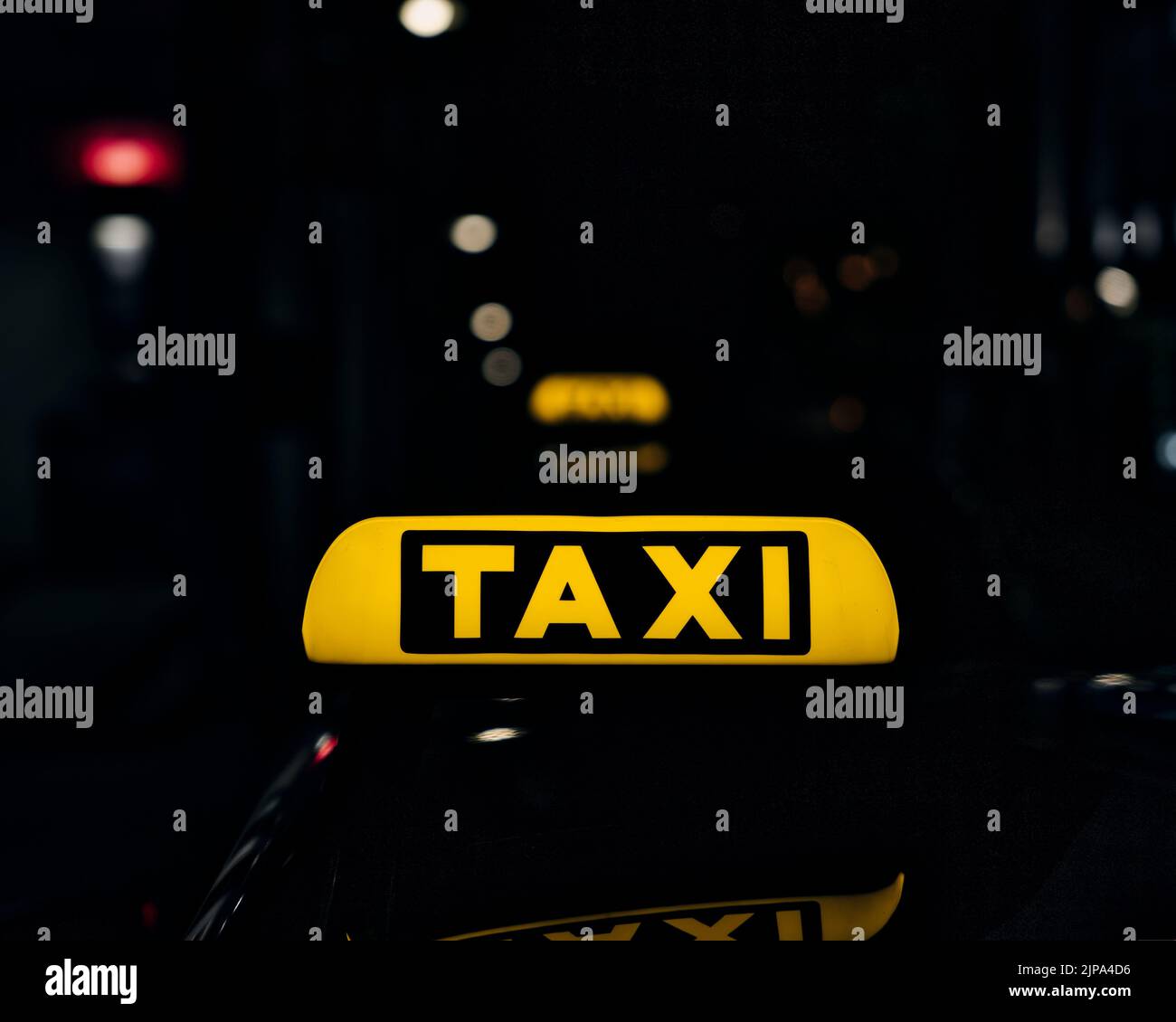 Ein Schild mit gelben Schildern auf dem Dach eines Taxiwagens in der Nacht Stockfoto