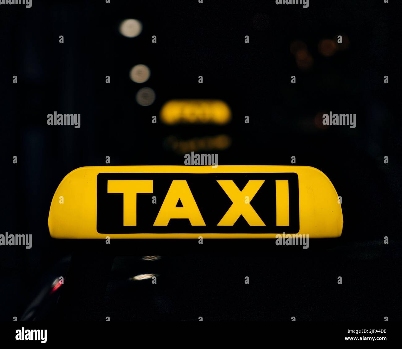 Ein Schild mit gelben Schildern auf dem Dach eines Taxiwagens in der Nacht Stockfoto