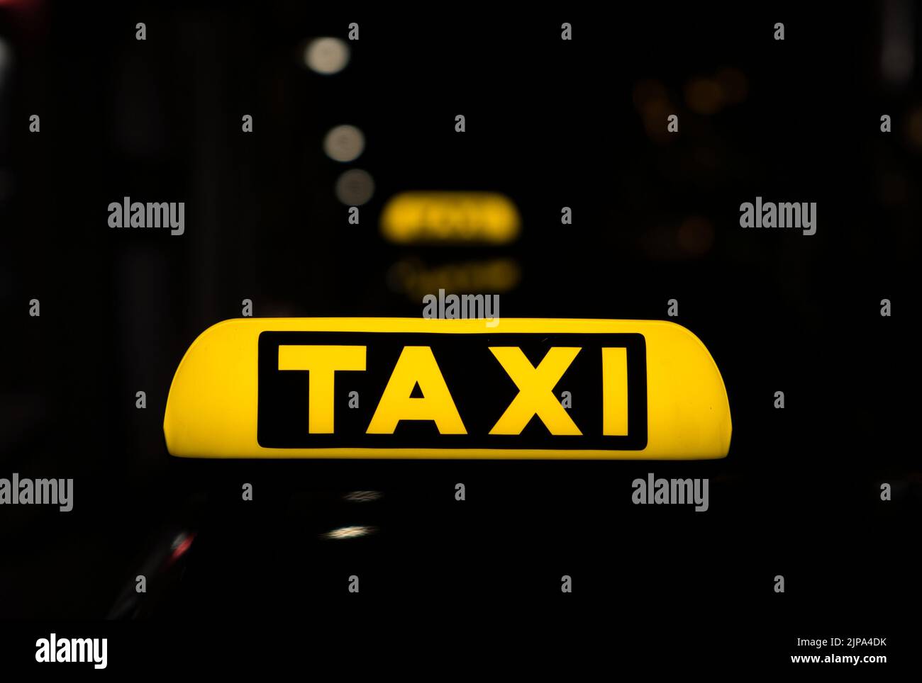 Ein Schild mit gelben Schildern auf dem Dach eines Taxiwagens in der Nacht Stockfoto