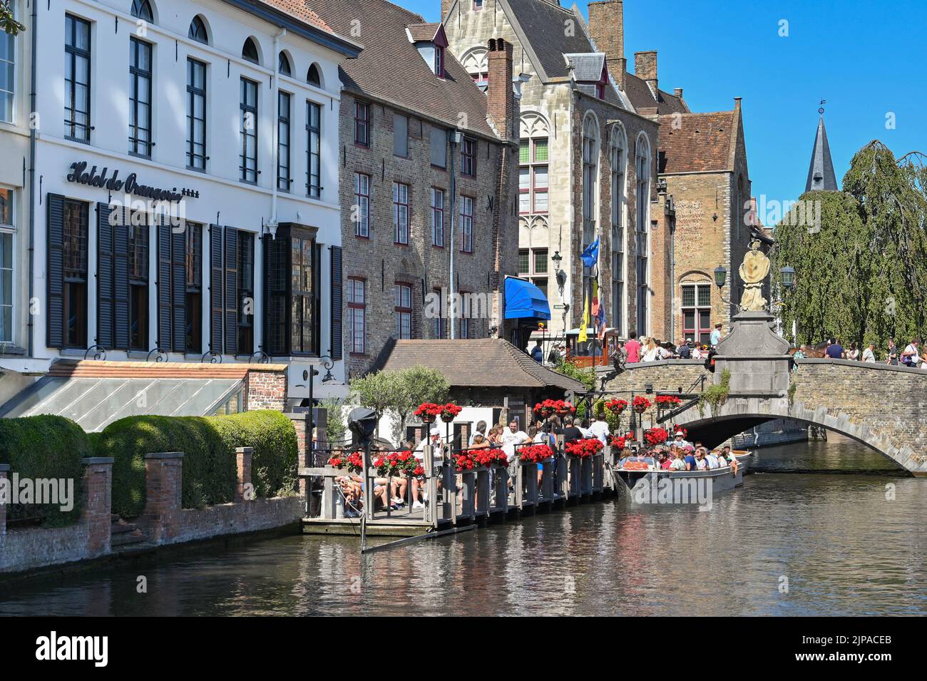 Brügge, Belgien - 2022. August: Gruppe von Touristen, die mit einem Motorboot um das Kanalsystem der Stadt fahren werden Stockfoto