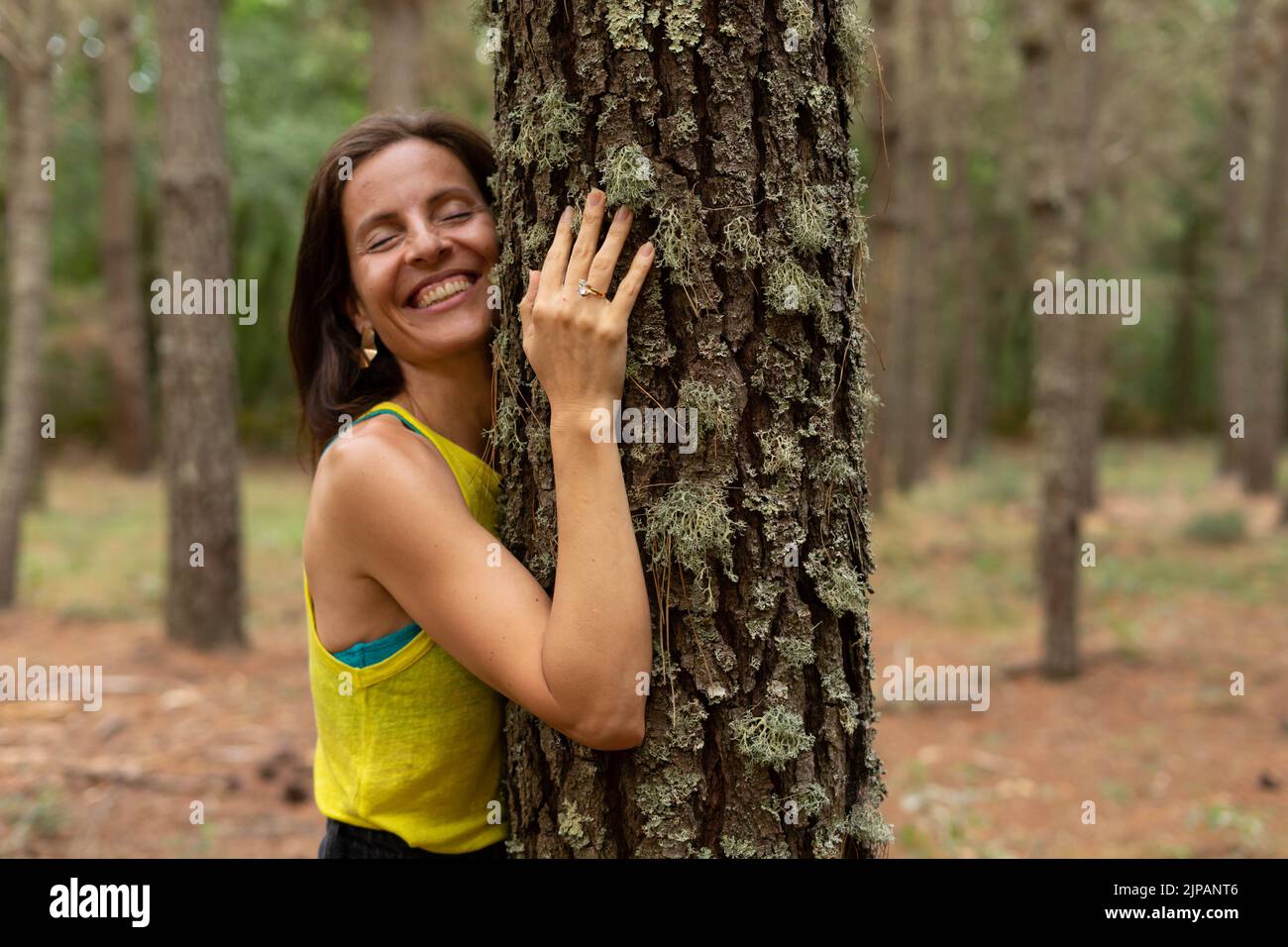 Frau umarmt einen Baum Stockfoto