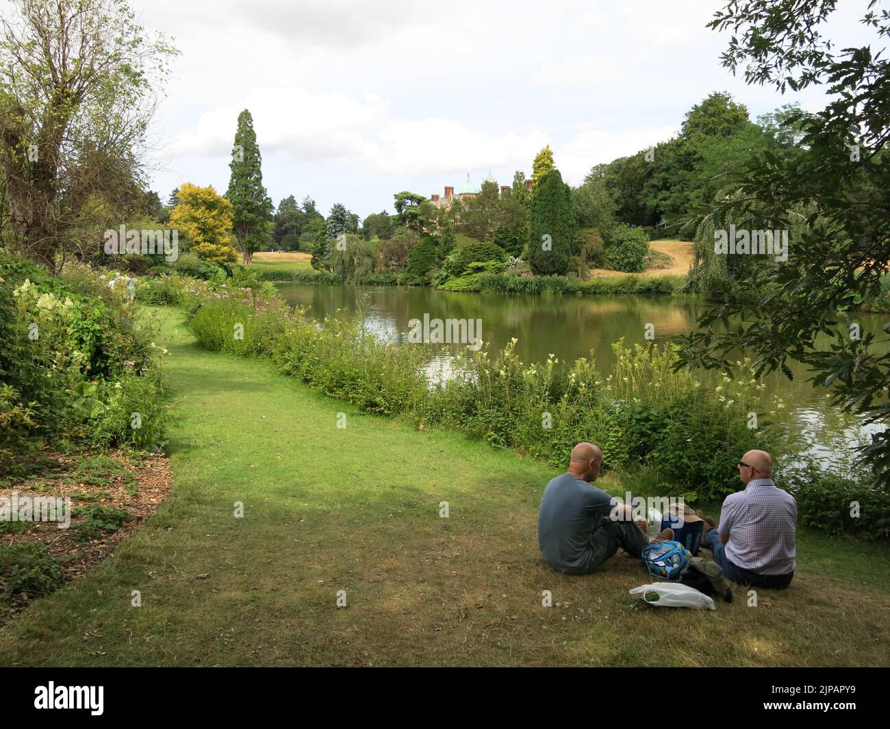 Zwei Männer saßen auf dem Gras am See auf dem Gelände des Sandringham Estate, einer königlichen Residenz im Besitz der Queen. Stockfoto