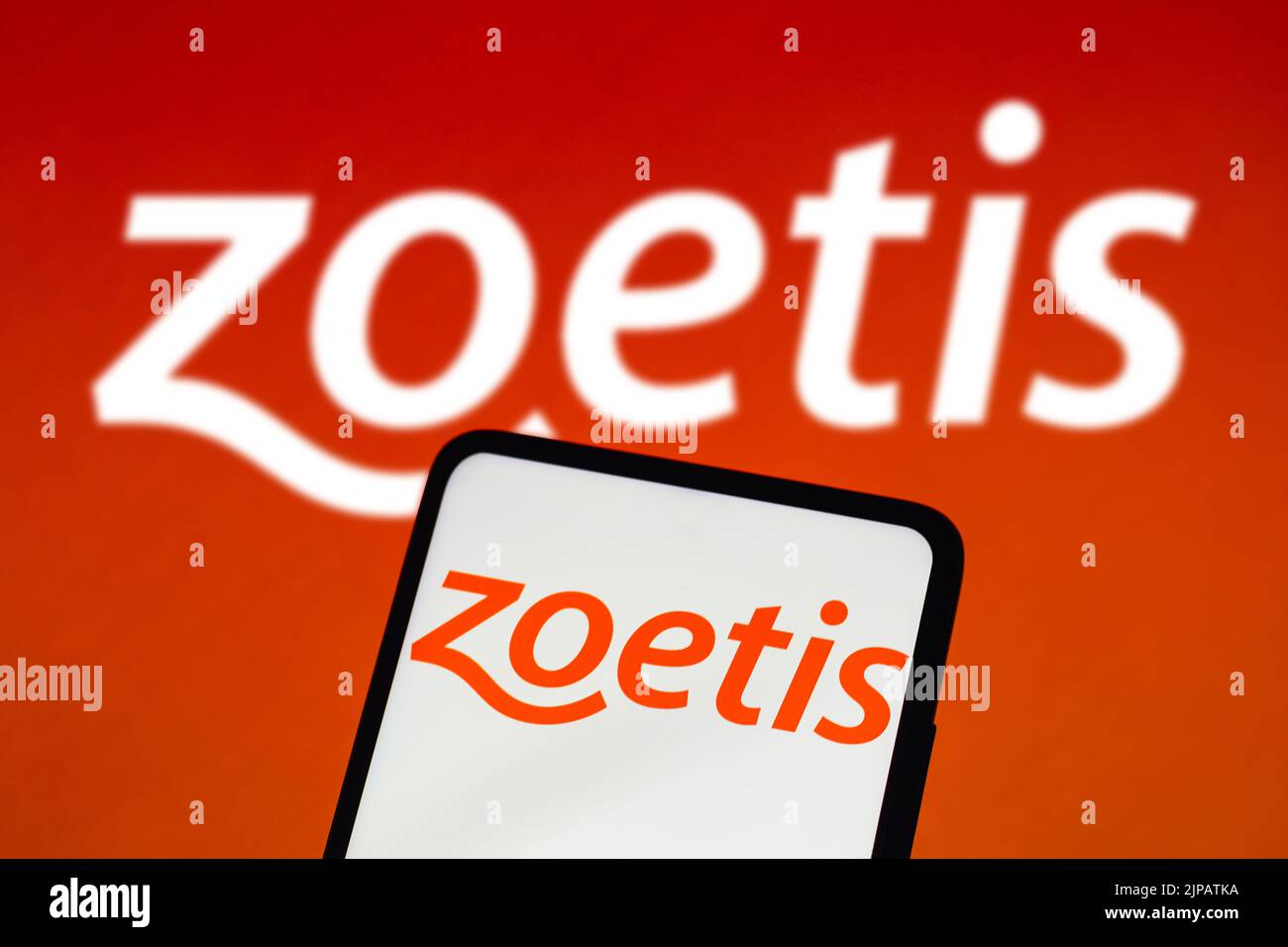 In dieser Abbildung wird das Zoetis-Logo auf einem Smartphone-Bildschirm und im Hintergrund angezeigt. Stockfoto