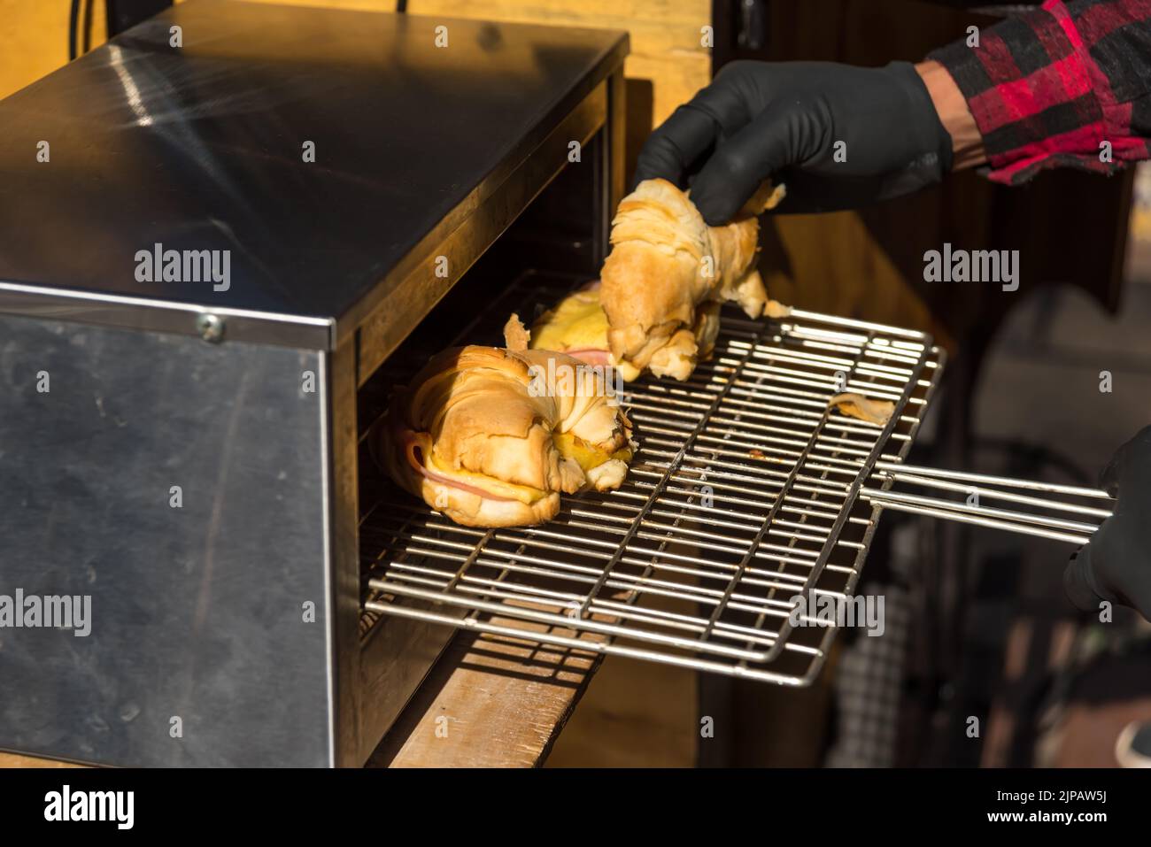 Eine Nahaufnahme eines Barista, der Croissants in einem Café aufwärmt Stockfoto