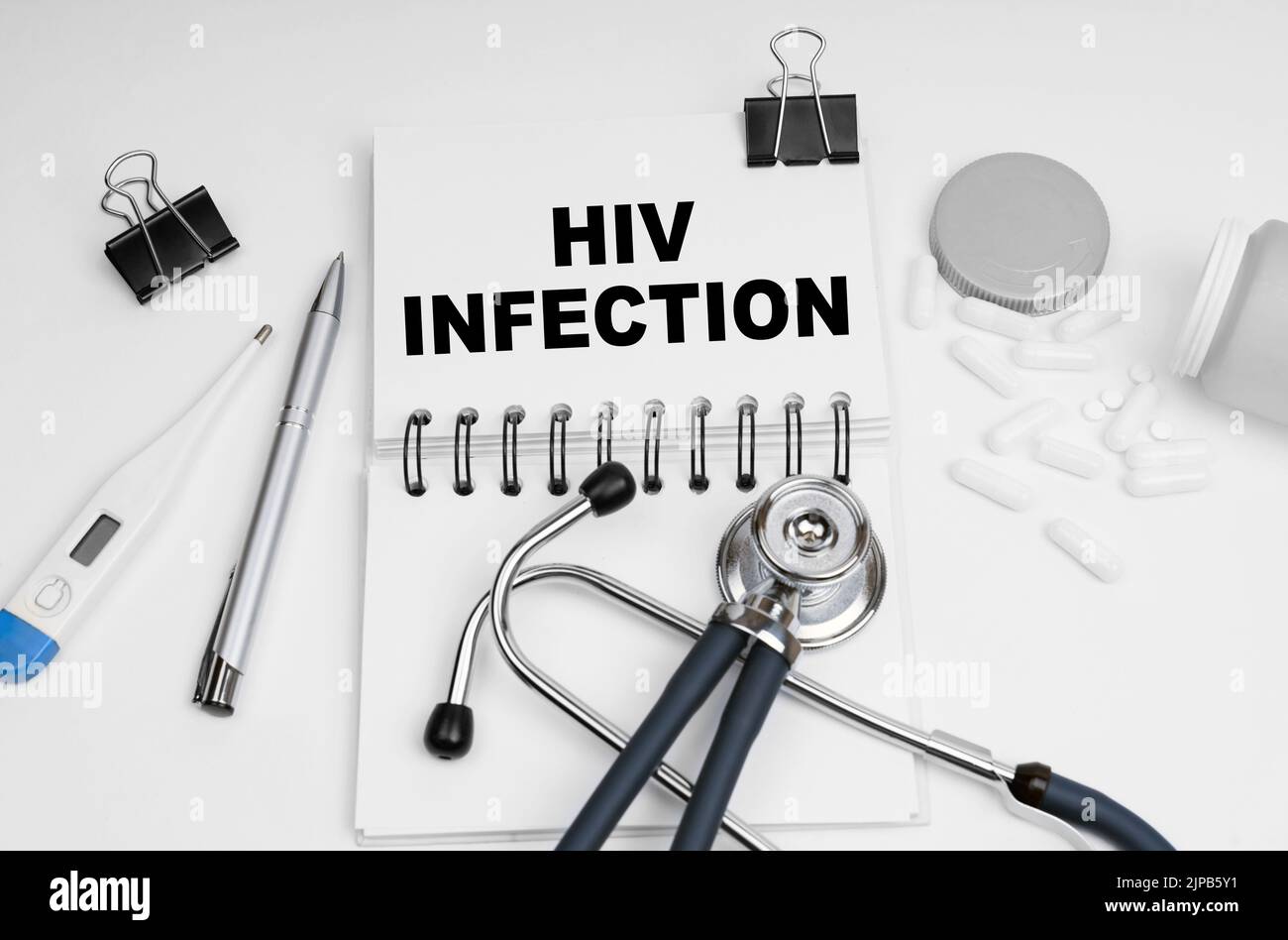 Medizinkonzept. Auf dem Tisch befinden sich ein Stethoskop, Pillen, ein Thermometer und ein Notizbuch mit der Aufschrift - HIV-Infektion Stockfoto