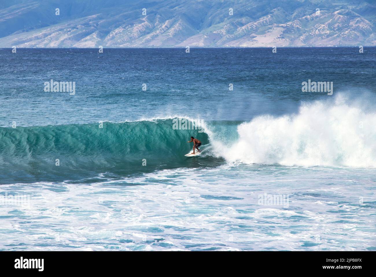 Entfernter, nicht identifizierbarer Surfer in der Röhre einer abschnürenden Welle. Stockfoto