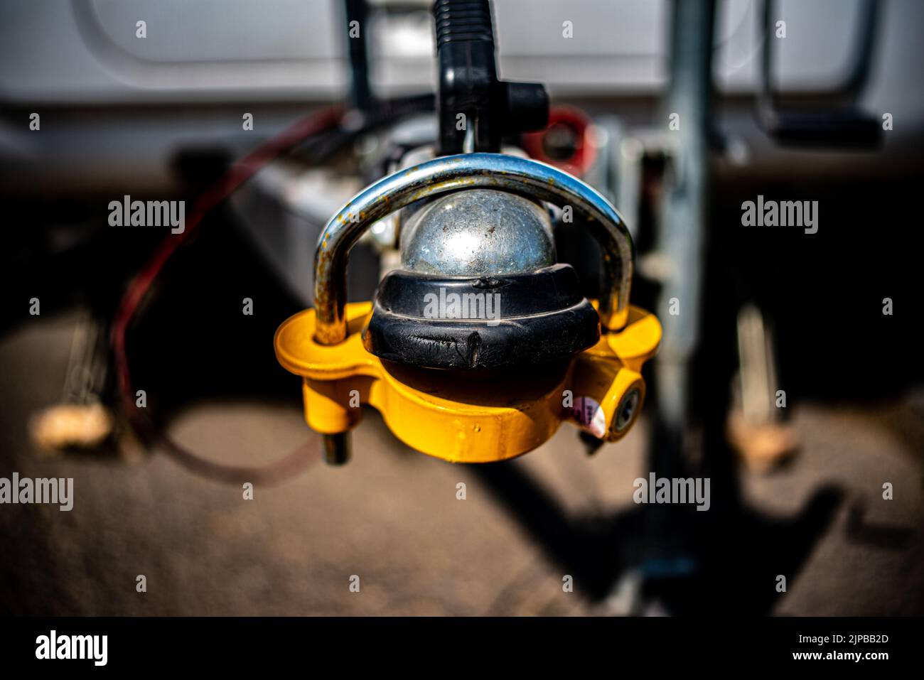 Gelbe Abschleppkugel, glänzende Kugel, alter Ball Auto Haken verbunden zu rostigen Chassis Nahaufnahme Stockfoto