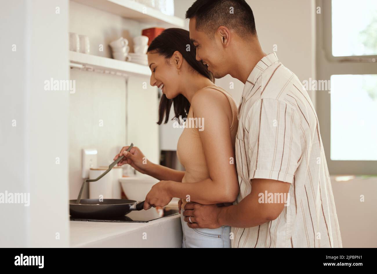 Romantisches, liebevolles und fürsorgliches Paar Kochen und Bonding während Umarmung am Morgen zu Hause. Lächelnder Ehemann und Ehefrau halten sich gegenseitig und umarmen sich Stockfoto