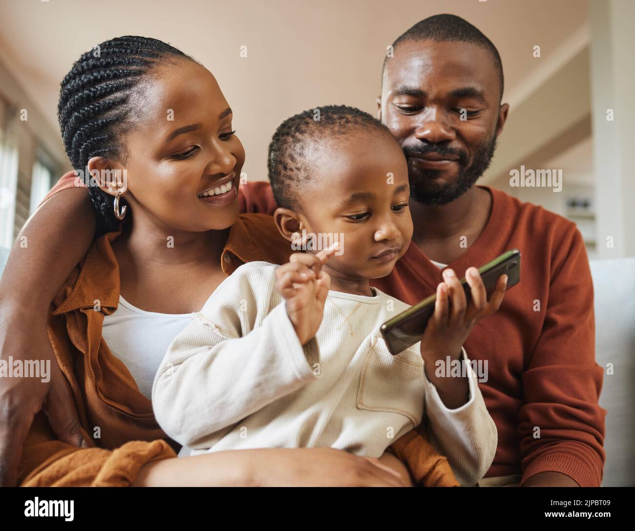 Glücklich, Bonding und Familie Zeit mit einer schwarzen Familie auf einem Videoanruf. Junge Eltern sind liebevoll mit ihrem Baby, während sie streamen und zuschauen Stockfoto