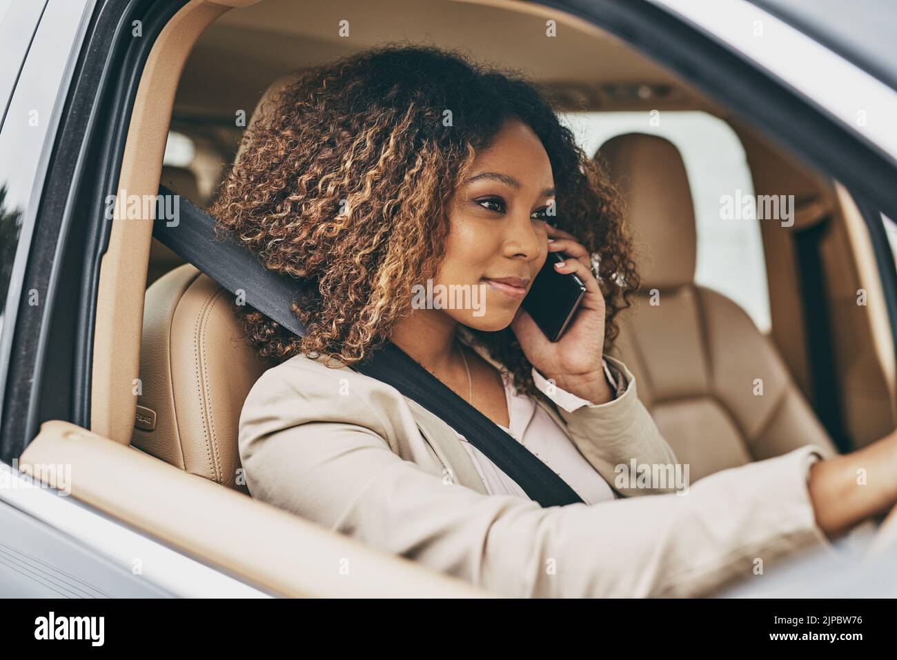 Kommunikation mit Kunden auf dem Weg zur Arbeit. Eine attraktive Geschäftsfrau, die während ihres morgendlichen Pendelvorgangs anruft. Stockfoto