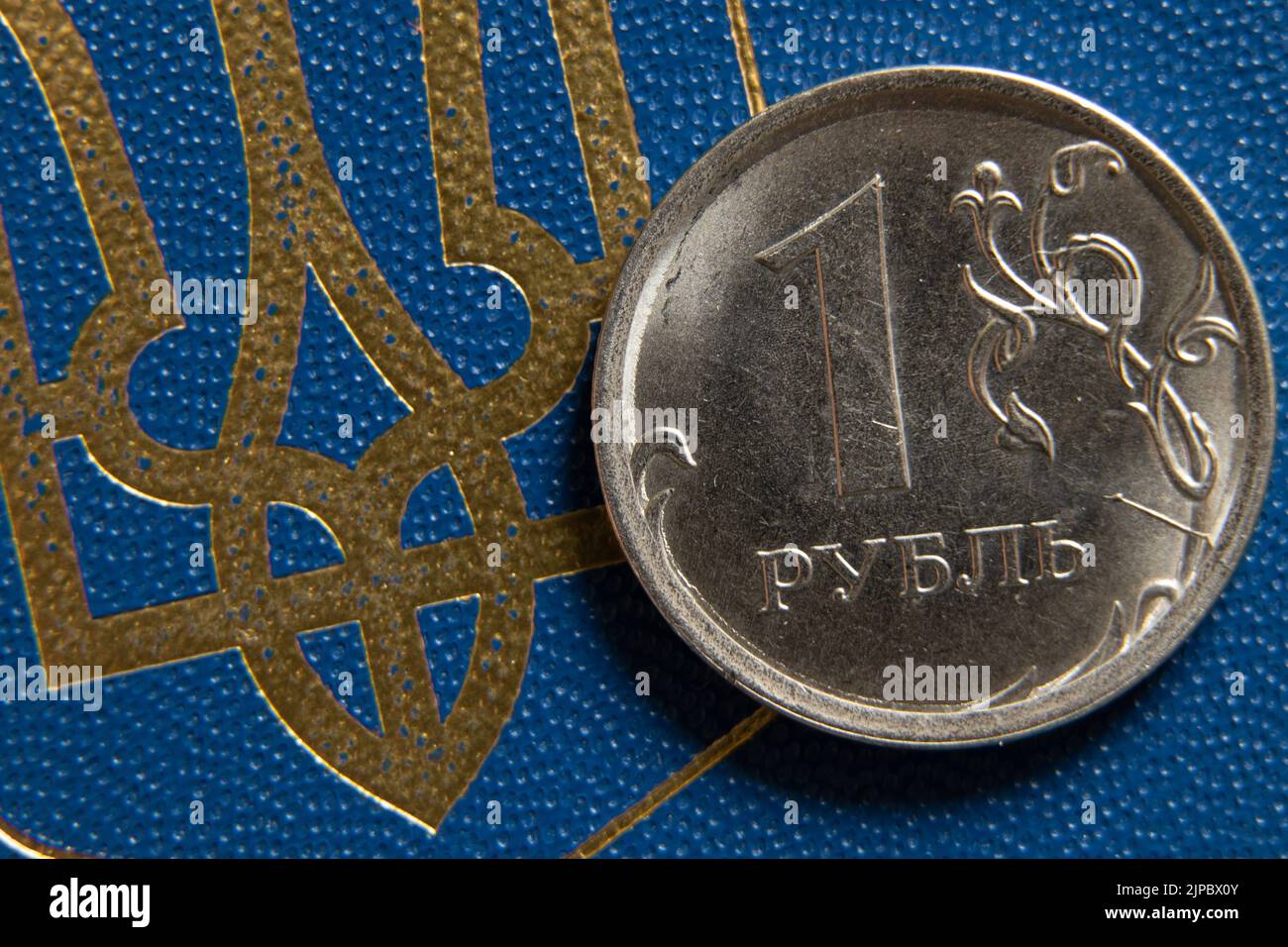 Russische Rubel und Wappen der Ukraine aus der Nähe. Finanzielle Sanktionen gegen Russland. Der Zusammenbruch des Rubels. Russische Wirtschaft und Rubel. Krise Stockfoto