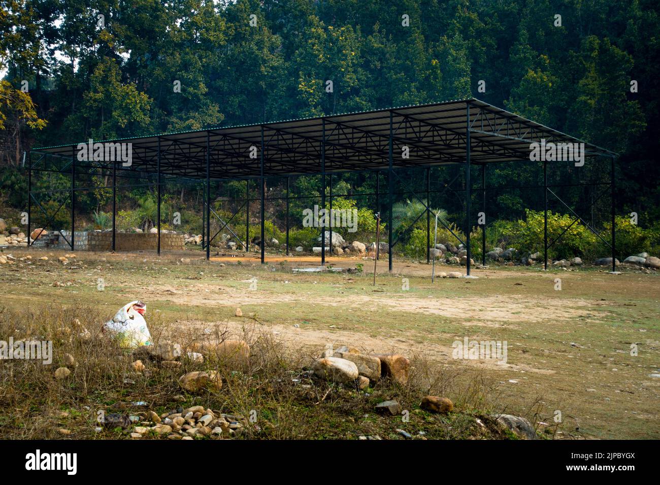 Öffnen Sie Das Shelter. Eine Metallkonstruktion mit Blechen und Pfosten arbeitet auf einem leeren Boden mit Bergen und Bäumen im Hintergrund. Dehradun Uttarakhan Stockfoto