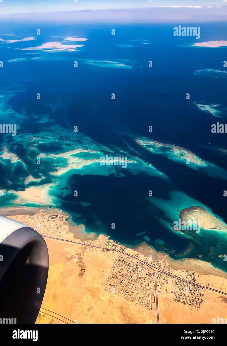 Luftaufnahme von oben von der Flugzeugküste Ägyptische Wüsteninseln. Rotes Meer Sharm Al Sheikh Ägypten. Erstaunlich schießen Vogel Auge Flugzeug Fenster Berge. Reisen Stockfoto