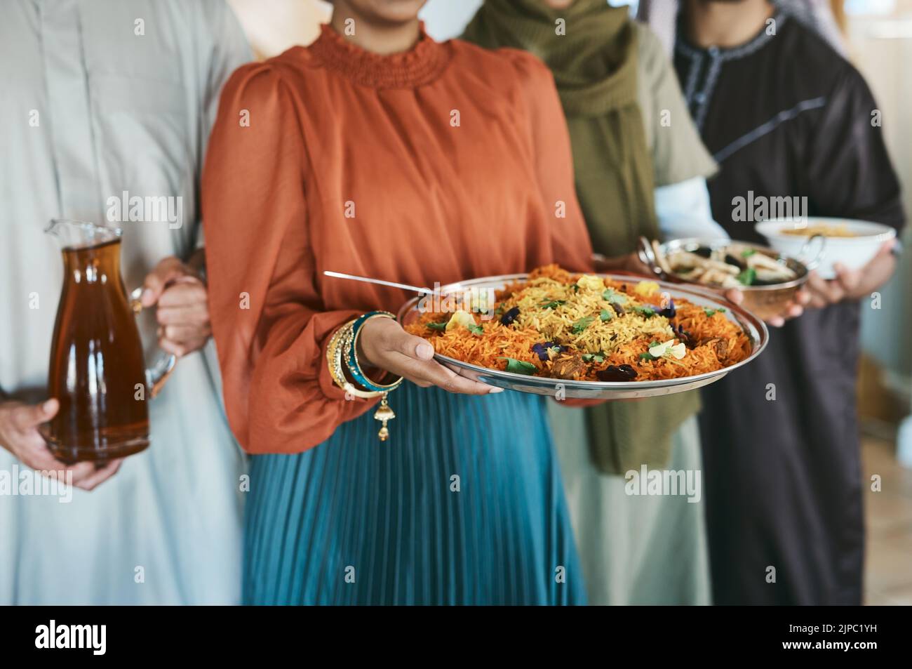 Ramadan, Eid und Iftar mit einer muslimischen Familie, die Essen und Trinken hielt, um ihr Fasten zu Hause gemeinsam zu brechen. Nahaufnahme von Reis und einem anderen in den Händen von A Stockfoto