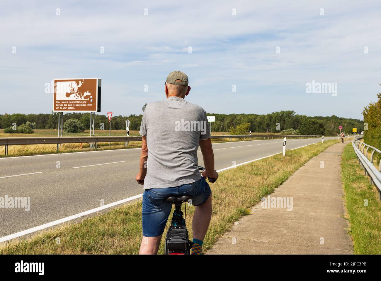 Domtiz, Deutschland - 2. August 2022: Tourist beobachtet das Gedenkschild an der ehemaligen innerdeutschen Grenze in Deutschland zum Gedenken an die deutsche Abteilung in Ost- und Westdeutschland Stockfoto